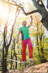 Full length of man with arms raised in forest