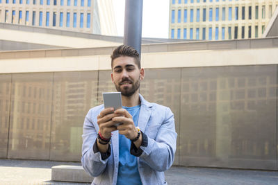 Portrait of young man standing in city