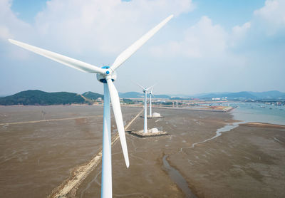 White wind turbines against the sky, a renewable energy concert.