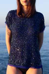 Portrait of young woman standing at beach