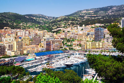 High angle view of boats moored at harbor by buildings against sky