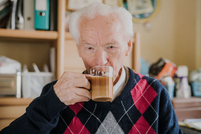 Portrait of man drinking coffee in glass