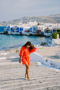 Full length of woman standing on beach against sea