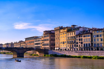 Bridge over river against buildings in city