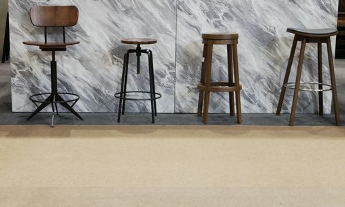 Empty chairs and table against wall