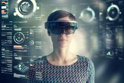 Woman wearing mixed reality smartglasses at transparent screen