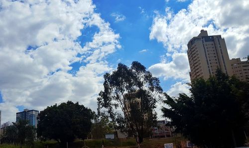 Low angle view of buildings against cloudy sky