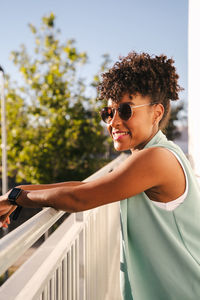 Portrait of man wearing sunglasses standing by railing