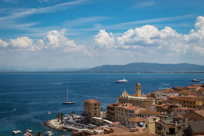 High angle view of townscape by sea against sky