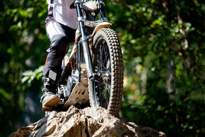 Low section of man riding motor bike on rock