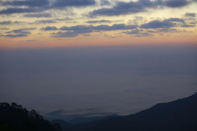 Scenic view of silhouette mountains against romantic sky at sunset