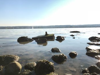 Rocks in sea against sky