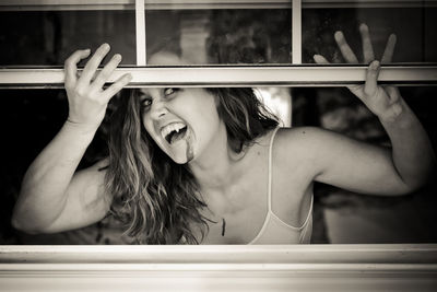 Portrait of spooky woman looking through window