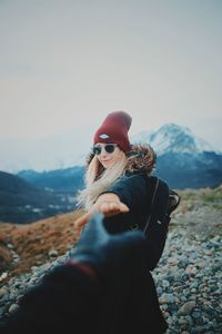 Midsection of woman against mountain range against sky