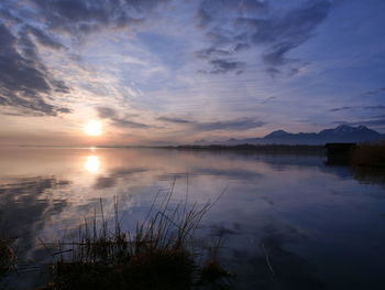 Scenic view of lake against sky at sunset