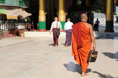 Rear view of people walking in temple