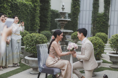 Side view of newlywed romantic couple holding bouquet