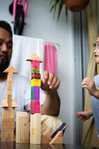 Low angle view of father playing with daughter at home