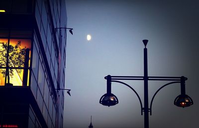 Low angle view of illuminated street light against sky