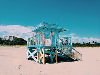 Lifeguard hut on beach against blue sky in miami beach