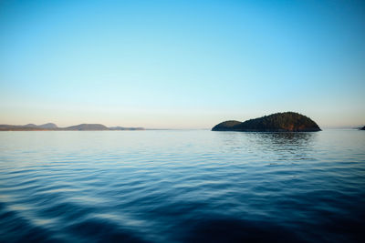 Idyllic view of sea against clear blue sky