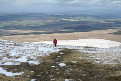 Full length of person walking on snow covered landscape