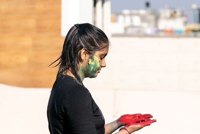 Side view of a girl playing with colors on the occasion of holi