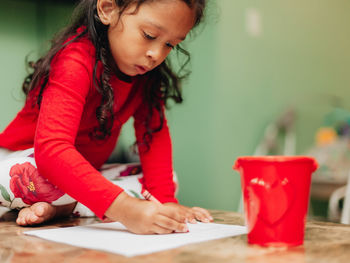 Close-up of girl looking away while sitting on table