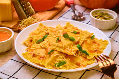 Homemade pumpkin ravioli with ricotta cheese served basil