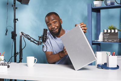 Senior man using digital tablet while sitting on table