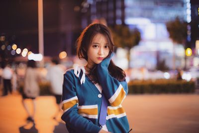 Portrait of woman standing in city at night