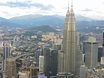 High angle view of petronas towers in city against sky