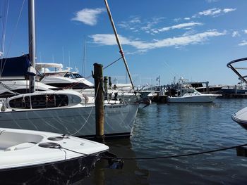 Sailboats in sea by city against sky