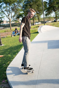 Rear view of man skateboarding in park