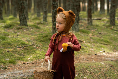 Girl standing on field in forest