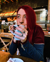 Portrait of young woman sitting at restaurant