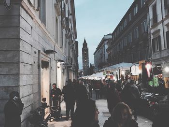 People on street in city against sky