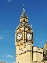 Low angle view of clock tower against blue sky