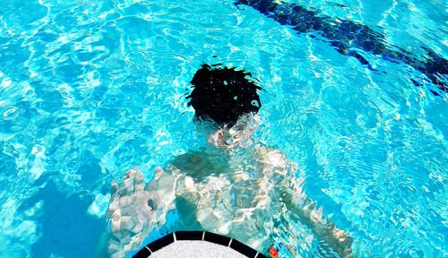 High angle view of boy swimming in pool