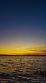 Scenic view of sea against clear sky at sunset