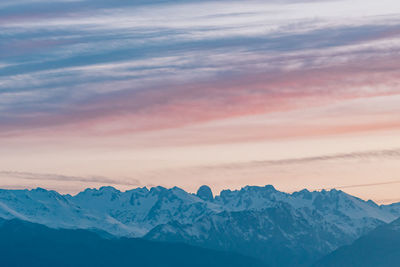 Scenic view of mountains against dramatic sky during sunset