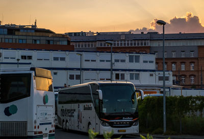 Train in city against sky during sunset