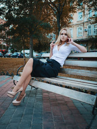 Young woman sitting on tree