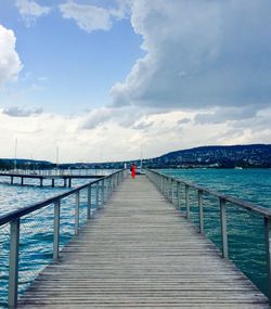 View of pier on sea against cloudy sky