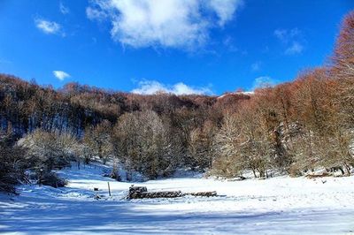 Scenic view of snow covered mountains against sky