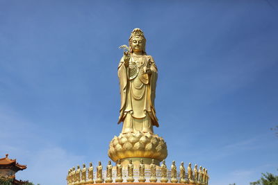 Low angle view of statue against blue sky