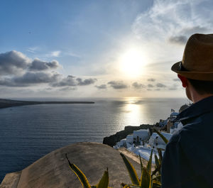 Rear view of man looking at sea against sky