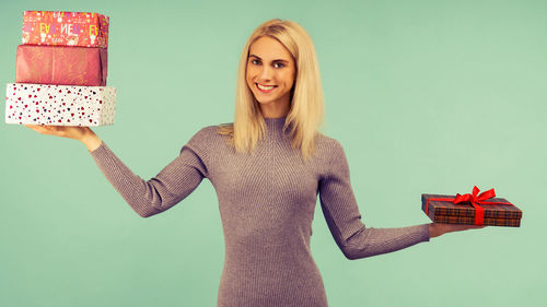Portrait of smiling young woman against gray background