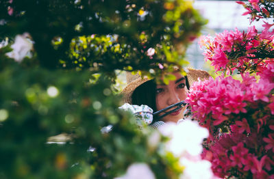 Close-up of woman by pink flowering plants outdoors