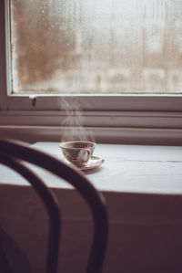 Hot coffee on window sill at home